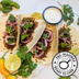 Soft tacos filled with The Better Butchers Chorizo plant-based ground, red onion, and coriander, with lime wedges.