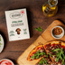 The Better Butchers Italian plant-based ground box on a wooden board with olive oil and a herb-topped flatbread.
