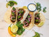 Four plant-based tacos made with The Better Butchers Chorizo-style ground, topped with pickled red onion, cilantro, and microgreens, served with crema and lime