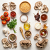 Assorted ingredients including mushrooms, tomatoes, herbs, and spices on a light background