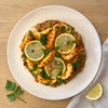 Plant-based paella with The Better Butchers shrimp-style pieces, saffron rice, bell peppers, parsley, and lemon
