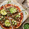 Plant-based taco pizza topped with The Better Butchers Chorizo-style ground, avocado, microgreens, and crema drizzle